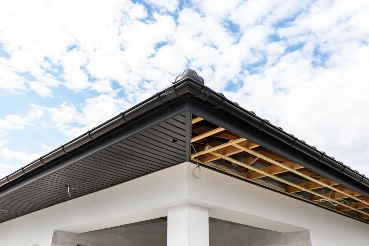 Building corner with black roof tiles and exposed wooden framework